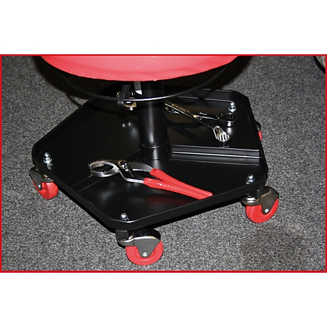 Un tabouret d'atelier noir avec un siège rouge, quatre roues rouges et un plateau avec des outils.